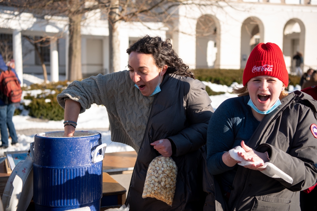 Students dunking hands in cold water as part of a Winterfest game.