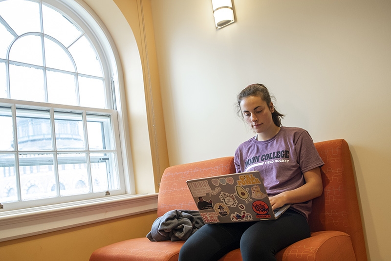 A student on one of the comfy chairs in Karp Hall