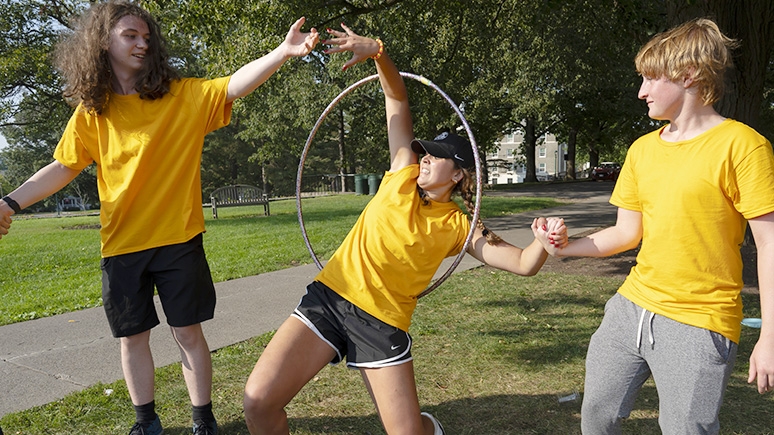 Students engaged in fun activity that involves slowly entering and exiting a hooped ring.