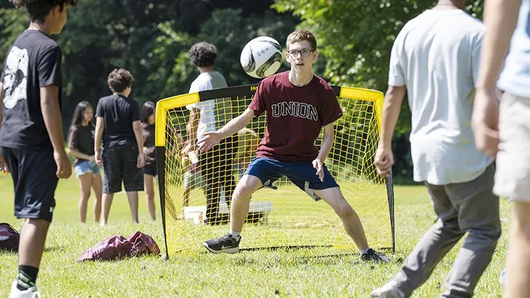 A student guards the net during a game of soccer