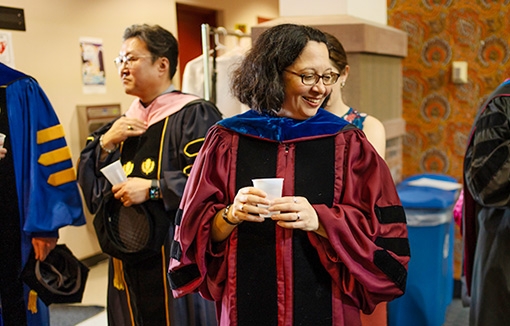 Stacie Raucci, the Frank Bailey Professor of Classics and chair of the department, mingles with colleagues in the lobby of Yulman Theater as they prepared to robe before Convocation. Raucci is the new College Marshal.