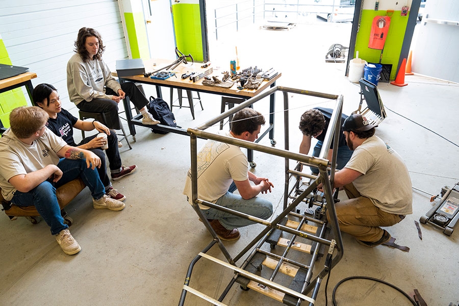 Students assembling the frame of a small vehicle used in the Baja racing competition
