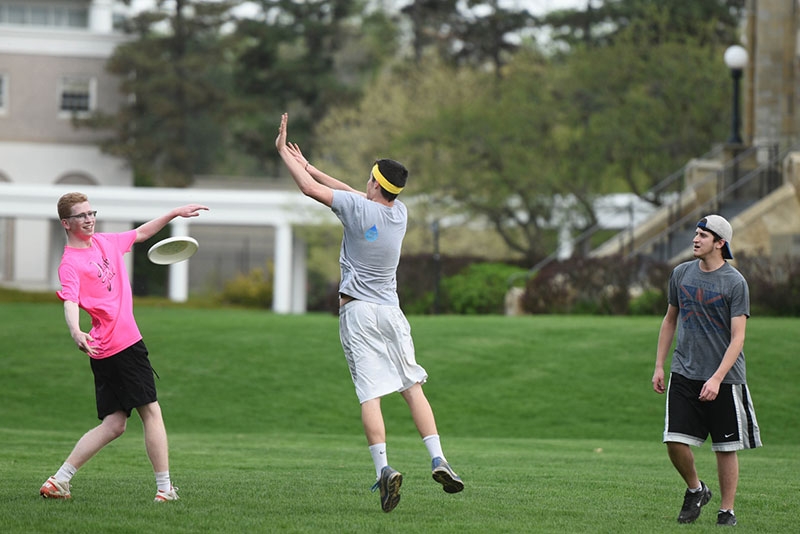 Students playing Frisbee on the campus green