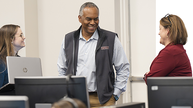 President Harris chats with some College Relations employees staffing a phon-a-thon