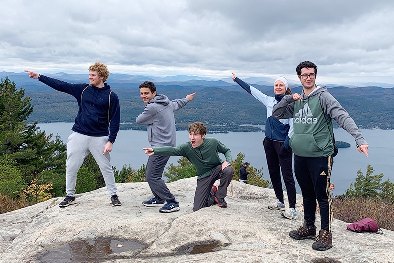 The outing club on top of a mountain with Lake George visible in the background.