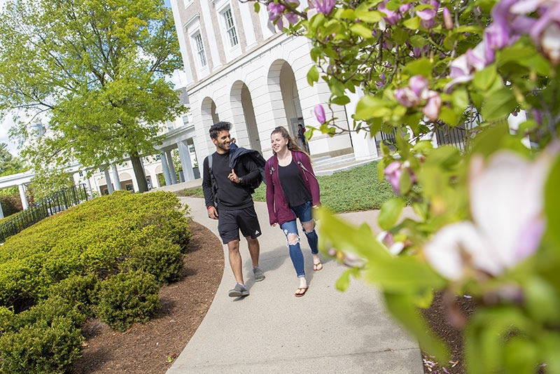 Students walking along a path that passes by Schaffer Library