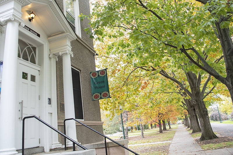 A view of the front door of Green House with tress in all their autumnal glory visible to the side.