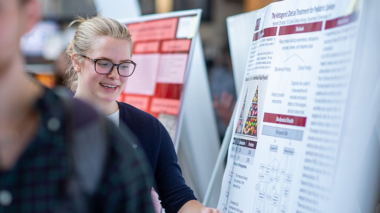 A student looks at a presentational poster at the Steinmetz Symposium