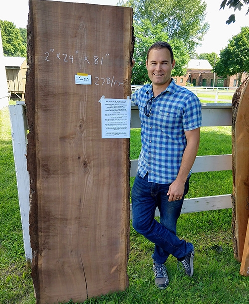 Jeff Jauregui proudly poses with his prized 200-year-old black walnut slab.