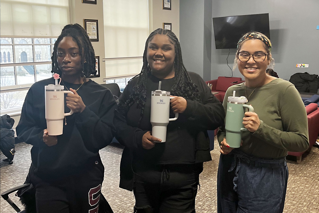 Three students with their Stanley Cup thermoses.