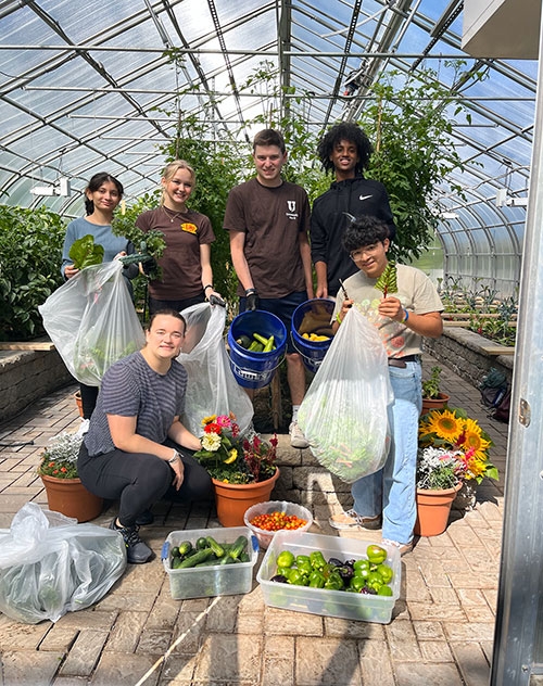 Students participating in pre-orientation 2023 work at the City Mission greenhouse, which is located at the home of David Leon '24.