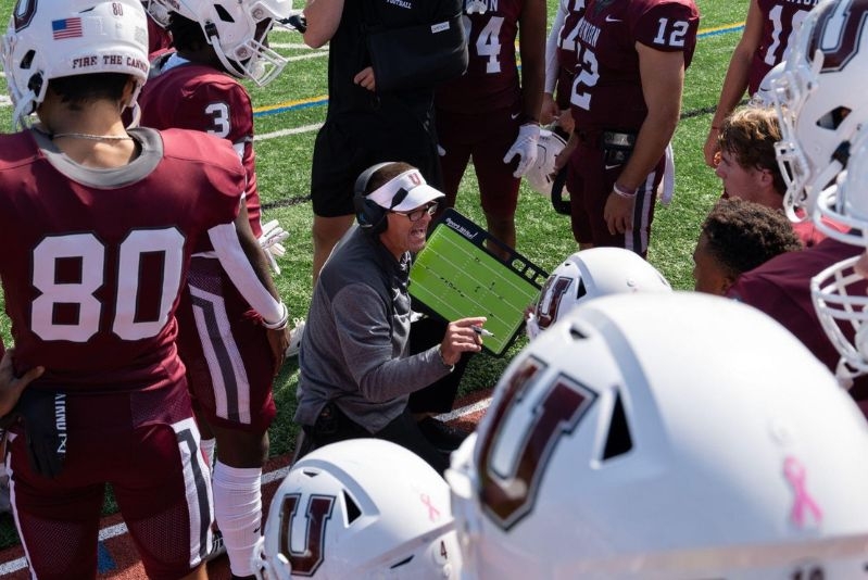 Football players surrounding coach on sideline