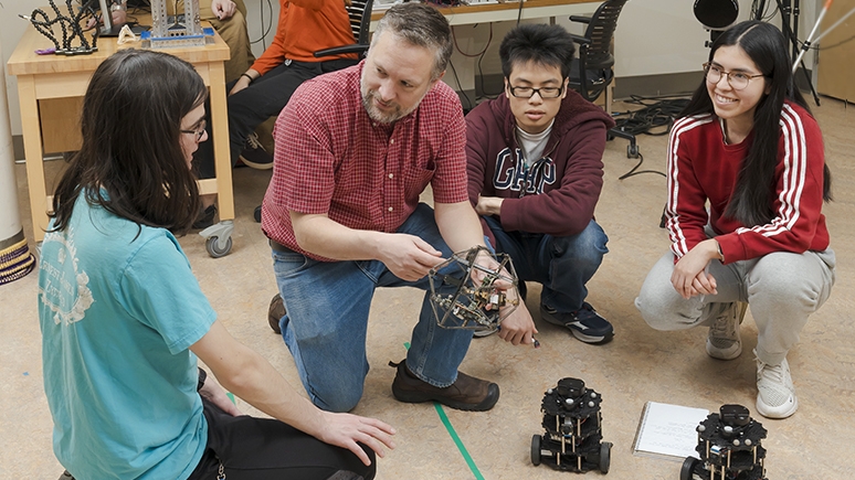 John Rieffel, professor of computer science and department chair,  works with students on tensegrity robots in the CROCHET Lab.  Rieffel’s research uses AI to optimize movements of these “soft  robots”—composed of rigid struts and springs—that have potential  applications in search-and-rescue, space exploration and surgery.  