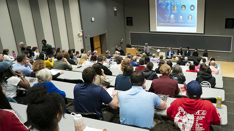 An auditorium full of students debating AI