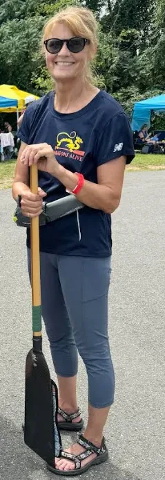 Traver poses with the paddle she uses in dragon boat racing.&nbsp;