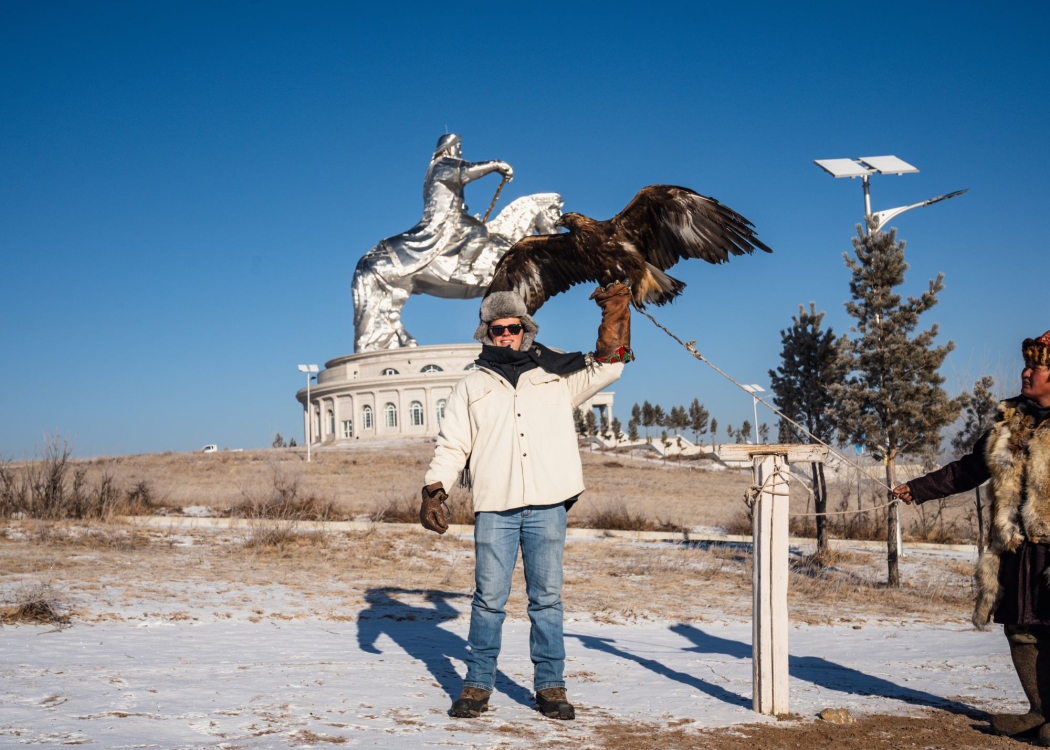 Student in Mongolia hold large bird