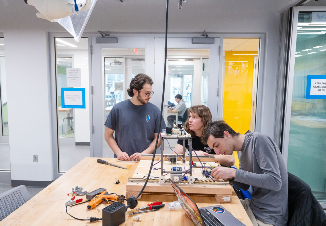 Union College students assembling components of a device in an engineering lab