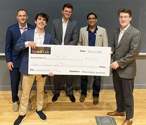SparkLab winners hold a large faux check