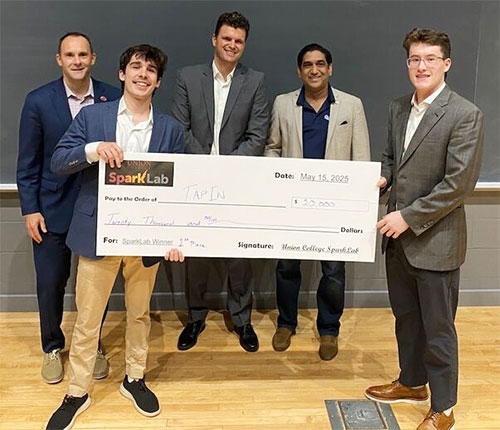 SparkLab winners hold a large faux check