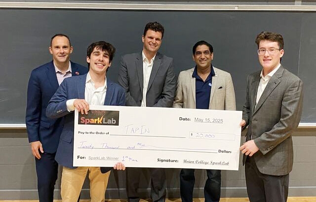 Sparklab winners hold a large faux check