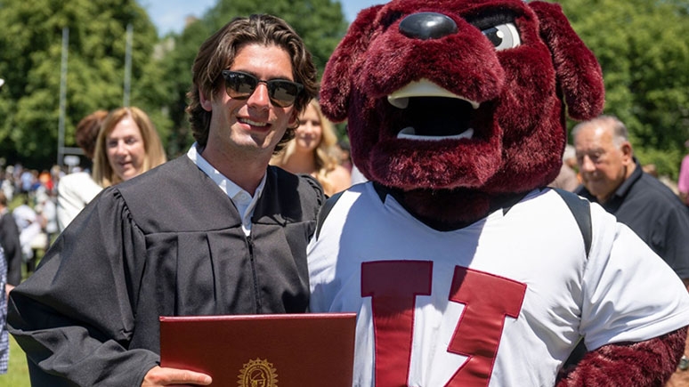 A Union grad poses with Charger, the Union College mascot