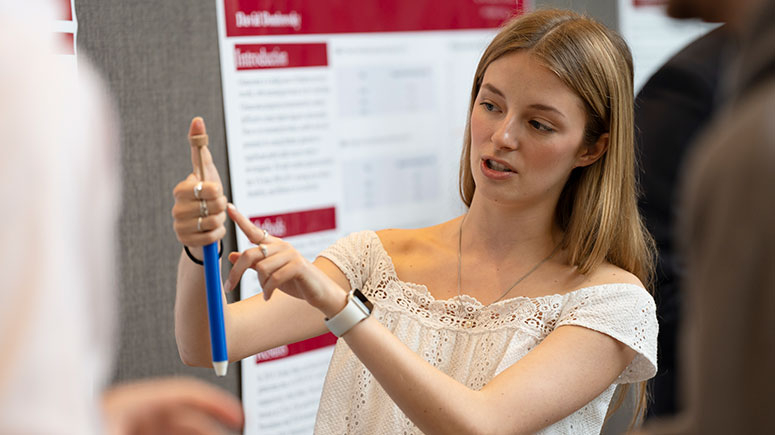 A student explains her research at the annual Steinmetz poster session.