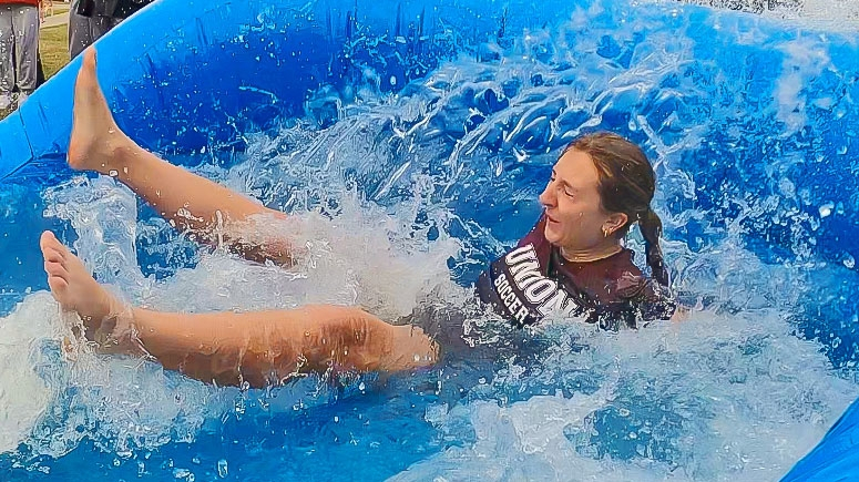 A student splashing in water during The Dip fundraiser