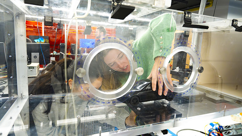 Students testing a model car in a wind tunnel
