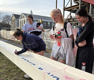 Students sign the beam