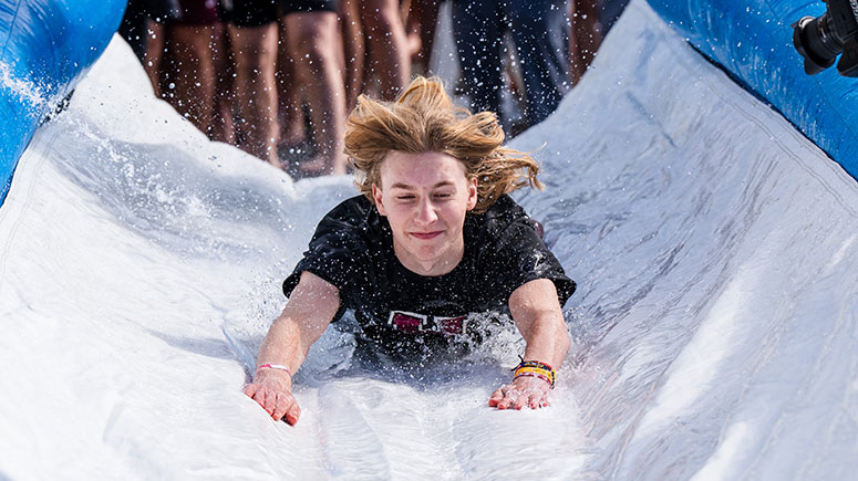 A student splashing in water during The Dip fundraiser
