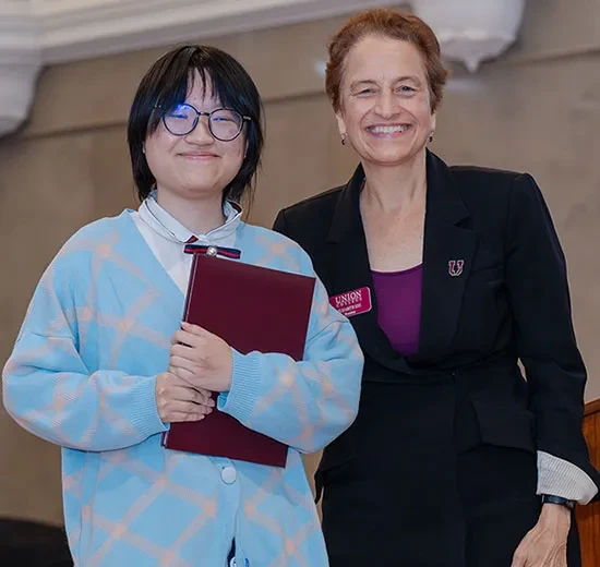 President Elizabeth Kiss presents Mai Tran ’26  with the Josephine Daggett Prize 