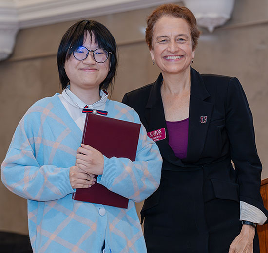 President Elizabeth Kiss presents Mai Tran ’26  with the Josephine Daggett Prize 