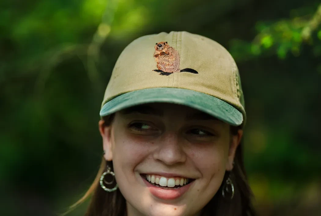 woman with a hat on that has a beaver on it
