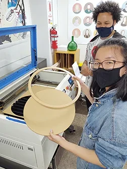 Student using laser cutter in Digital Arts Lab.