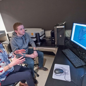A faculty member and student viewing the micro-CT imaging system