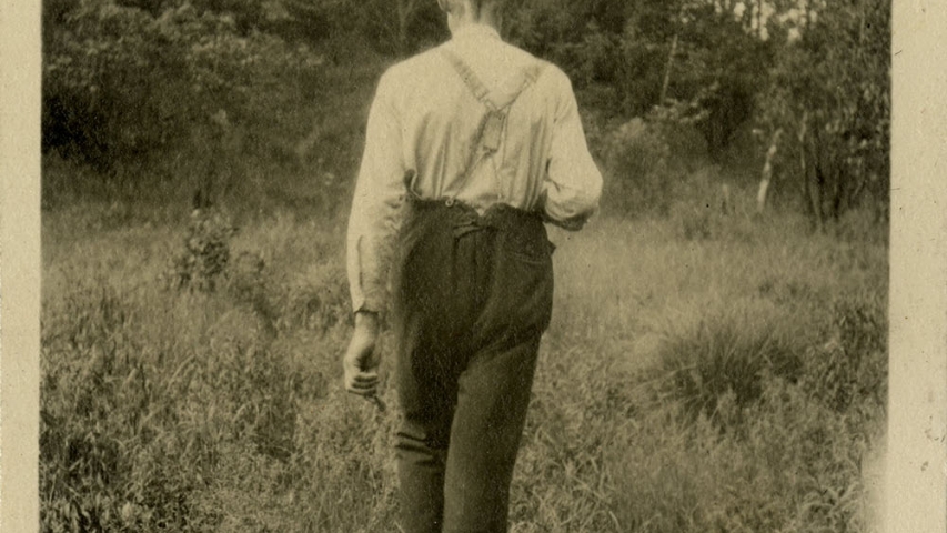 Marshall Family Collection: Guide Herb Clark Man walks into forest away from camera.