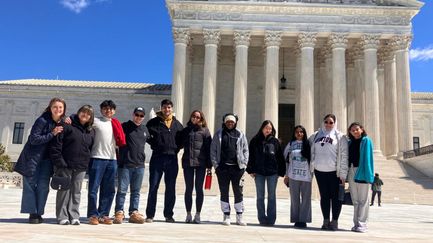 11 People standing in winter gear in front of US supreme court