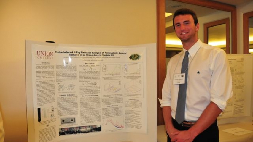 Ben Nadareski next to poster at the 4th Joint Meeting (2014) of the Nuclear Physics Division of the APS