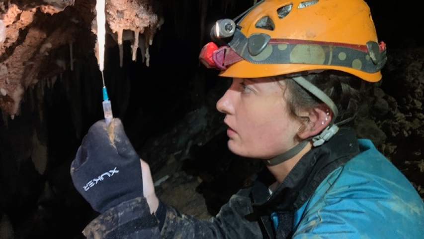 A geology student takes a sample while working in Peru