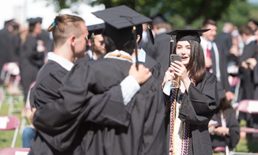 Graduates taking photos of one another