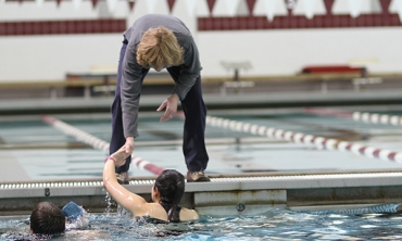 Trainer Cheryl Rockwood high fives a student in the pool.