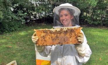 Gabriela Basil '22, a member of Union's Beekeeping Club, inspects a hive.