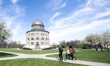 Students walking across campus with the Nott Memorial in the background