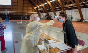 Celeste Beaudoin ’24 has her temperature checked by registered nurse Joan Thompson in the COVID-19 testing site in Memorial Field House. 