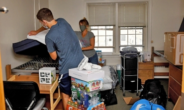 A student moving into a dorm room on campus