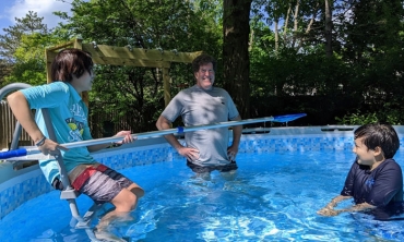 Chad Orzel in the pool with his children