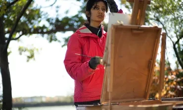 A student paints outdoors 