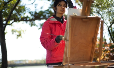 A student paints outdoors 