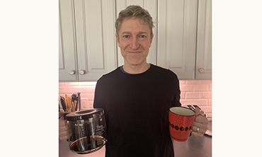 Robert Samet in kitchen with coffee mug and coffee pot in his hands.