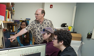 Professor Francis Wilkin discusses the interpretation of an exoplanet light curve with Niha Das '26, left, Will Grimwood '24 and Dimitris Vasileios Zora '26, right.